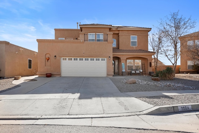 view of front of home with a garage, driveway, a tile roof, and stucco siding