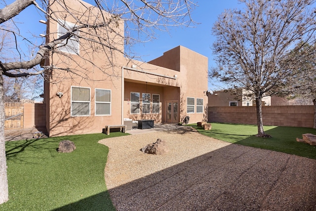 back of property featuring a lawn, fence, a patio, and stucco siding