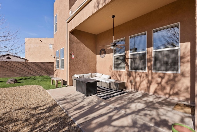 view of patio featuring a ceiling fan, fence, and an outdoor living space