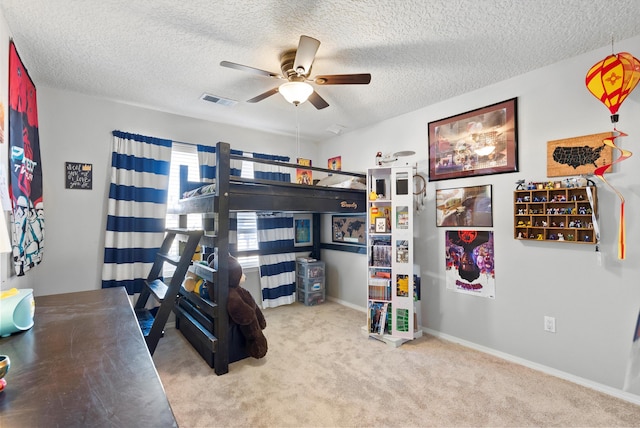 carpeted bedroom featuring a textured ceiling, ceiling fan, visible vents, and baseboards