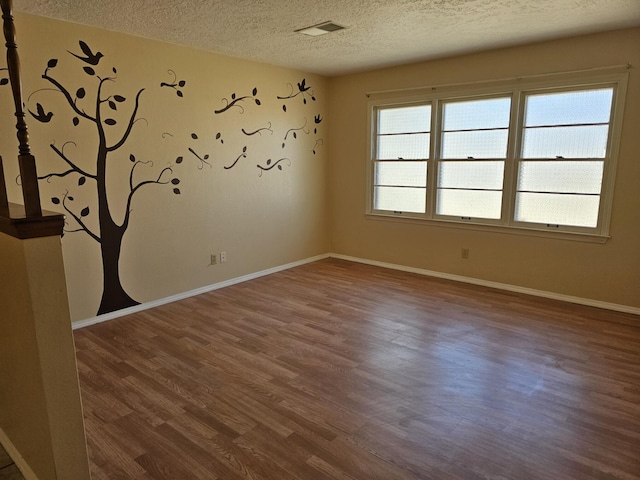 unfurnished room featuring a textured ceiling and dark wood-type flooring