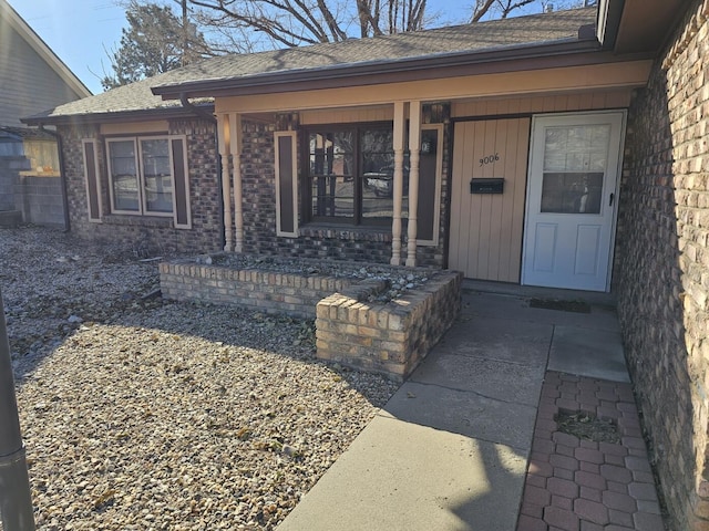 view of exterior entry featuring covered porch