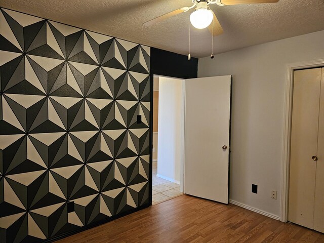 unfurnished room featuring a textured ceiling, ceiling fan, and hardwood / wood-style floors