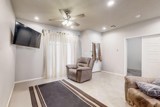 living area with ceiling fan and light tile patterned floors