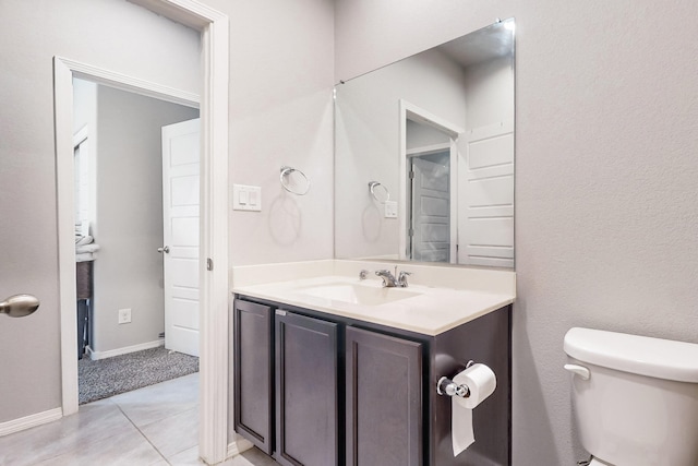 bathroom featuring tile patterned floors, vanity, and toilet