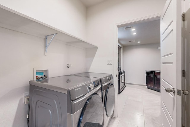 laundry room featuring washing machine and dryer and light tile patterned floors