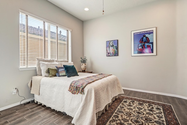 bedroom with wood tiled floor, multiple windows, and baseboards