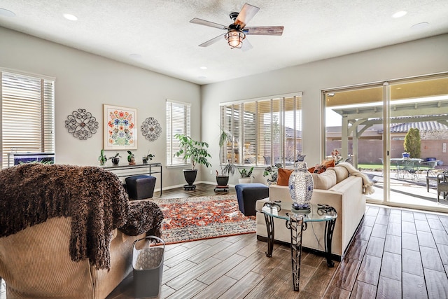 living room with a ceiling fan, wood tiled floor, and a textured ceiling