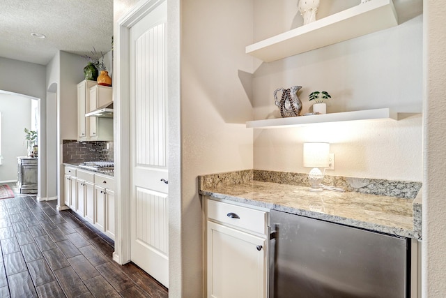 bar featuring tasteful backsplash, dark wood finished floors, wine cooler, a textured ceiling, and stainless steel gas stovetop