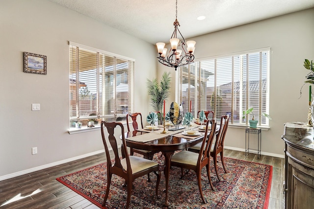 dining room with a chandelier, baseboards, and wood finished floors