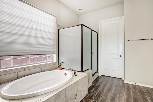 bathroom with a bath, a shower stall, and wood finished floors