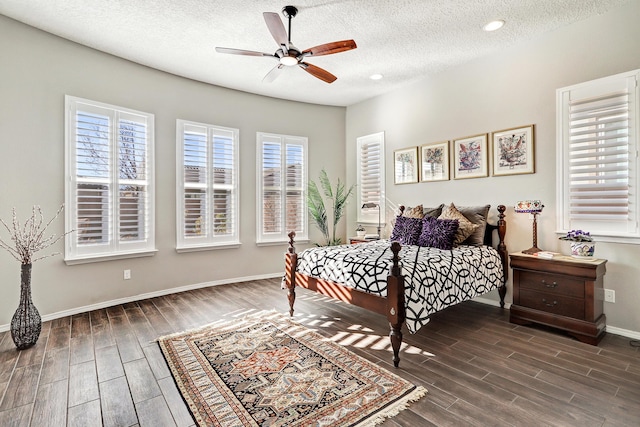 bedroom featuring a ceiling fan, wood tiled floor, a textured ceiling, and baseboards