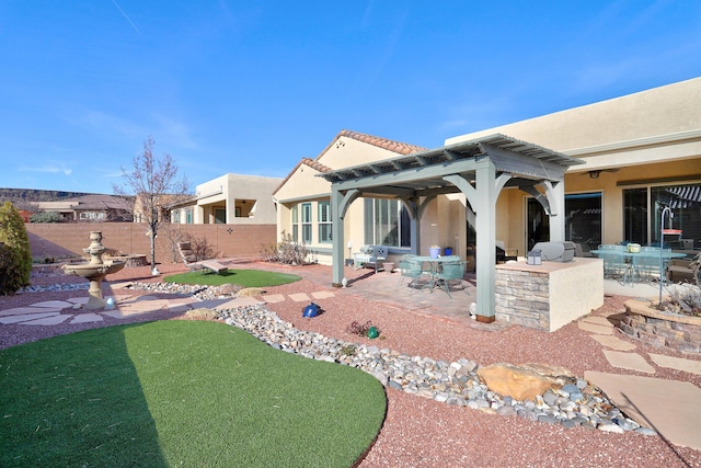 rear view of house with outdoor dining area, a patio area, fence, and stucco siding