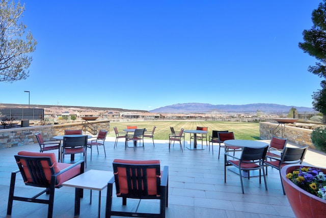 view of patio / terrace with a deck with mountain view and outdoor dining area