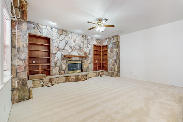 unfurnished living room featuring ceiling fan, carpet flooring, and a fireplace