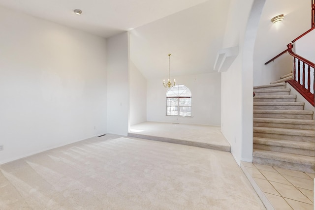 spare room featuring an inviting chandelier and carpet floors