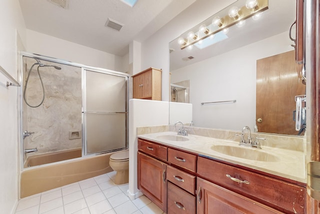 full bathroom featuring combined bath / shower with glass door, tile patterned flooring, vanity, and toilet