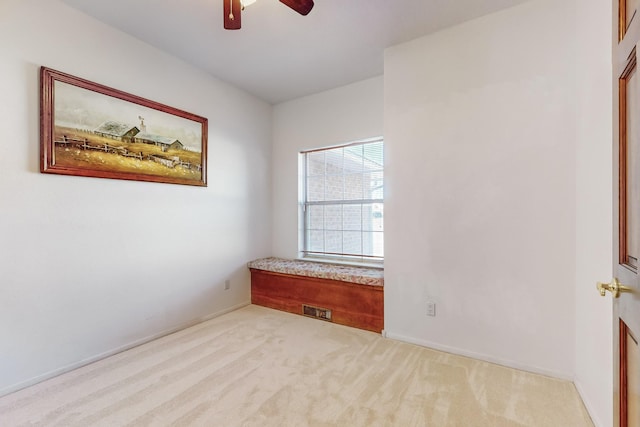 carpeted spare room featuring ceiling fan