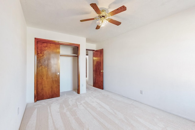 unfurnished bedroom with ceiling fan, a closet, and light carpet