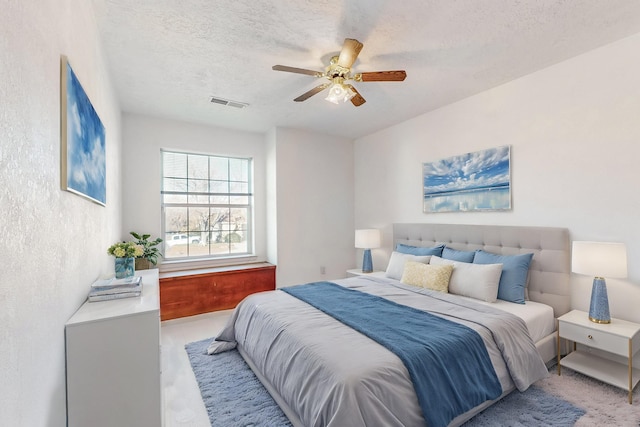 bedroom featuring ceiling fan and a textured ceiling