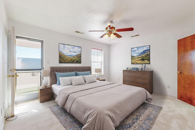 carpeted bedroom featuring a textured ceiling and ceiling fan