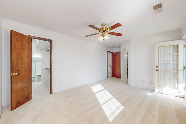 empty room featuring ceiling fan and light colored carpet