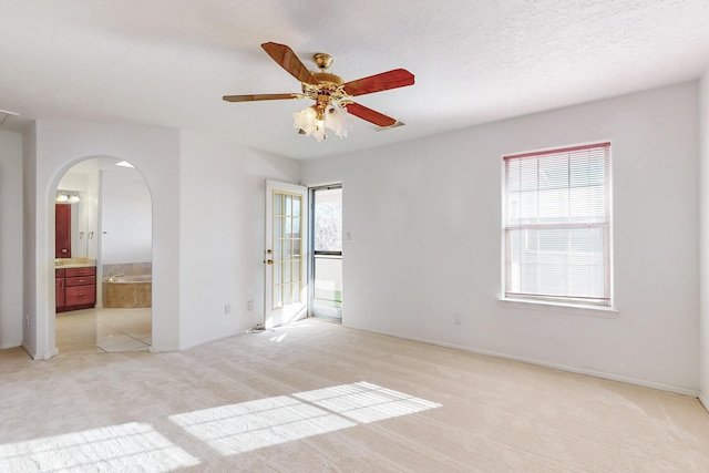 empty room with ceiling fan and light carpet