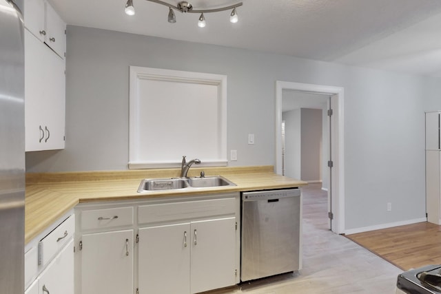 kitchen featuring light countertops, white cabinets, appliances with stainless steel finishes, and a sink