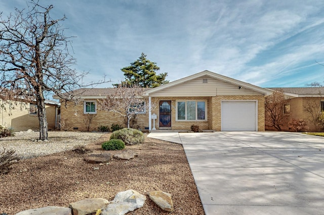 single story home with a garage, brick siding, driveway, and crawl space