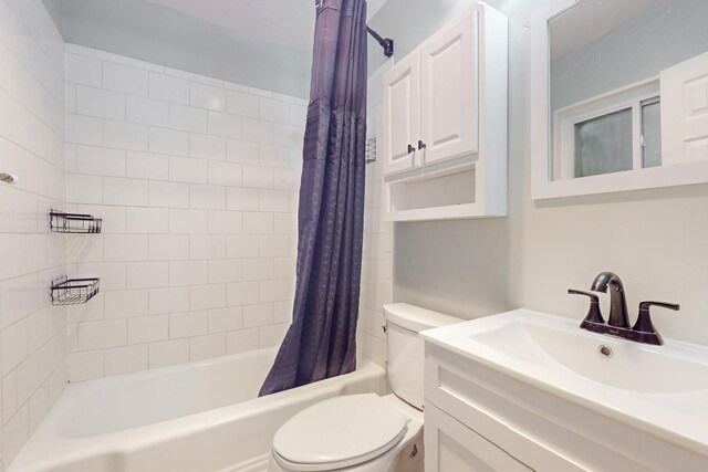 bathroom featuring toilet, shower / bath combo, and vanity