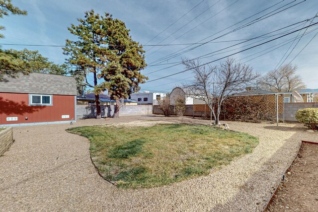 view of yard featuring an outbuilding and fence