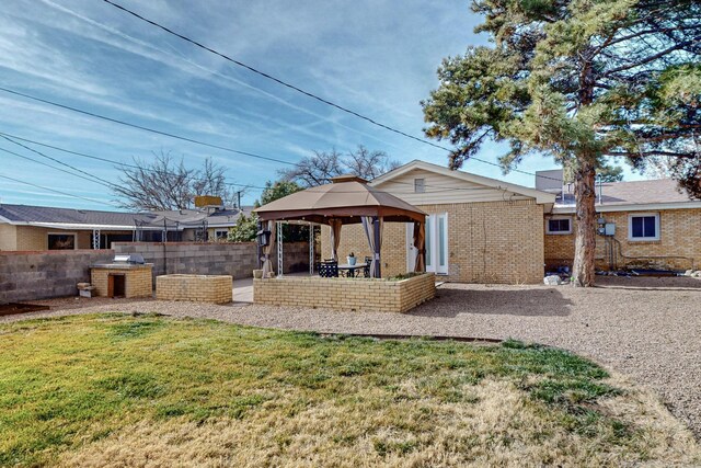 back of property featuring a patio, fence, a gazebo, a lawn, and brick siding