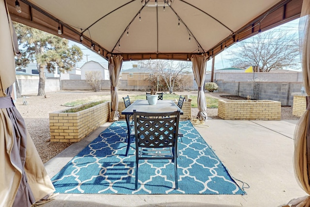 view of patio / terrace featuring a gazebo, outdoor dining area, and a fenced backyard