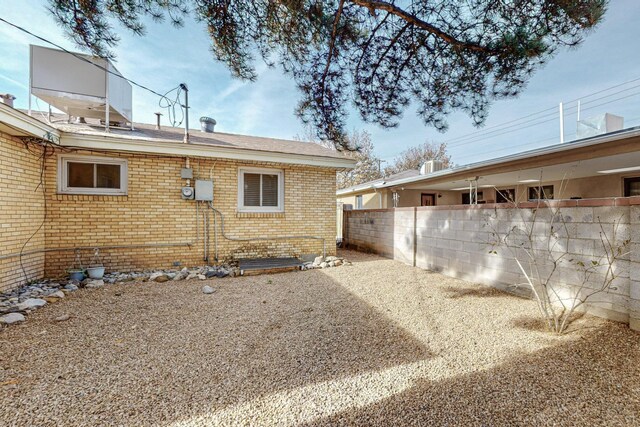 view of home's exterior with a patio area, fence, and brick siding