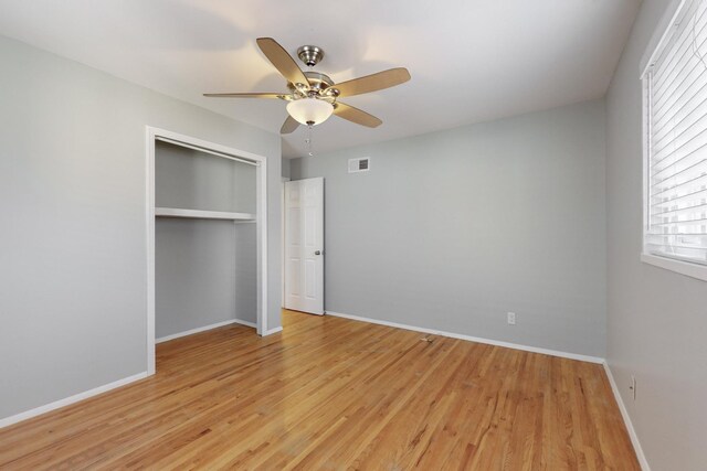 unfurnished bedroom featuring visible vents, baseboards, light wood-style floors, and a closet