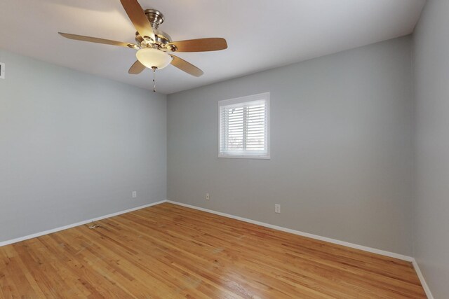 spare room with a ceiling fan, visible vents, baseboards, and light wood-type flooring