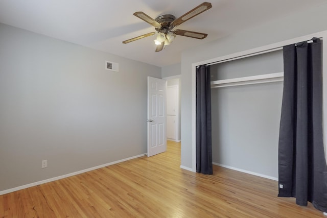 unfurnished bedroom with a ceiling fan, visible vents, baseboards, light wood-style floors, and a closet