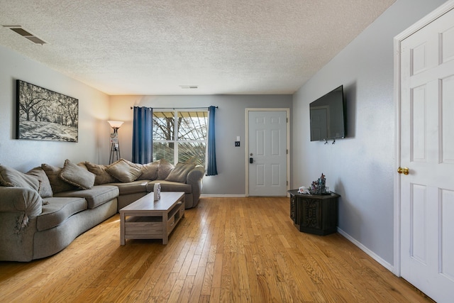 living room with light hardwood / wood-style floors and a textured ceiling