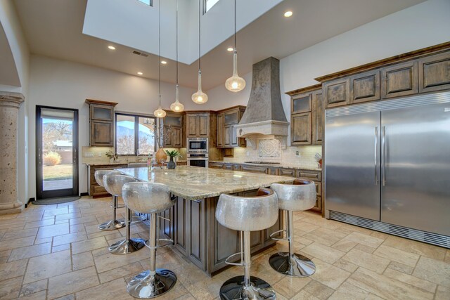 living room with a fireplace, a towering ceiling, ceiling fan, and beamed ceiling