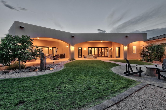 back of house featuring a lawn and a patio