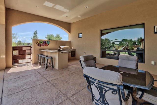 view of patio / terrace featuring exterior kitchen, a grill, and an outdoor bar