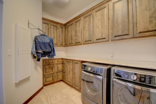 washroom with independent washer and dryer, cabinet space, and baseboards