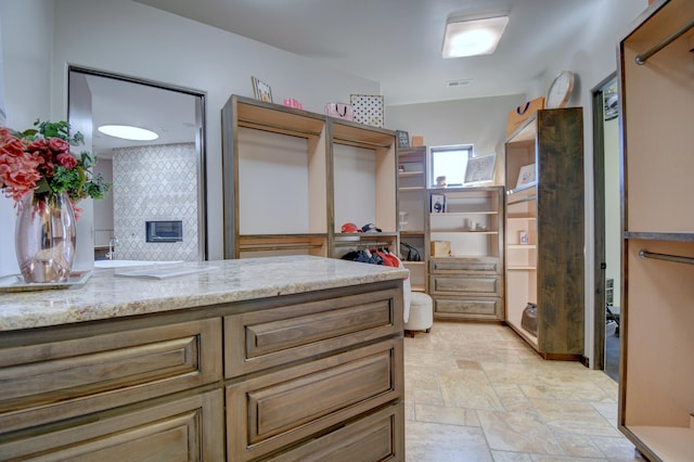 interior space featuring stone finish flooring, visible vents, and a closet