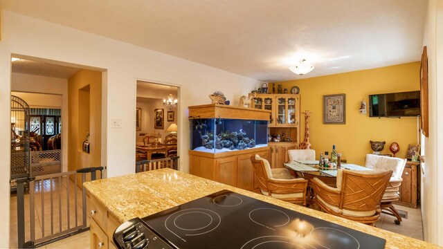 kitchen featuring light stone countertops, stove, and light tile patterned floors