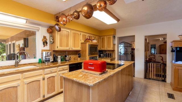 kitchen with built in microwave, sink, a kitchen island, light stone countertops, and decorative backsplash