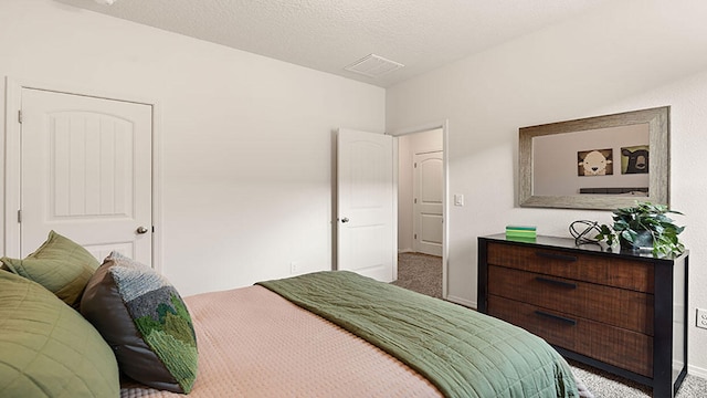 bedroom with carpet and a textured ceiling