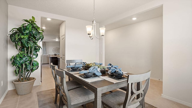 dining area featuring light tile patterned floors, a textured ceiling, and an inviting chandelier