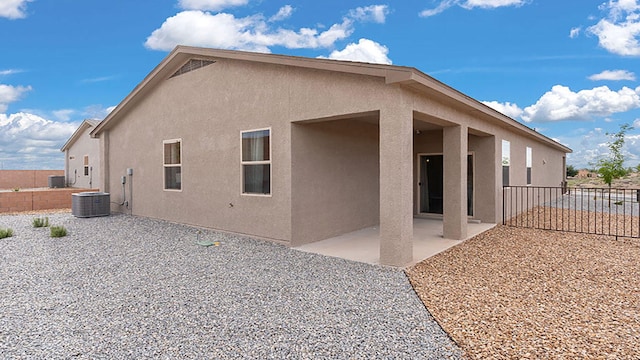 rear view of house featuring central AC unit and a patio area