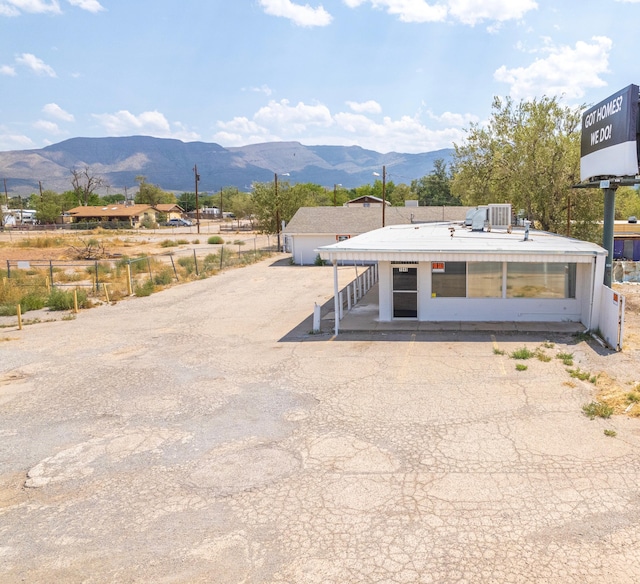 view of front of home featuring an outdoor structure, fence, and a mountain view