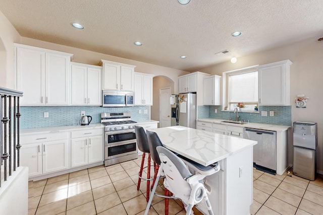 kitchen with appliances with stainless steel finishes, white cabinetry, and sink